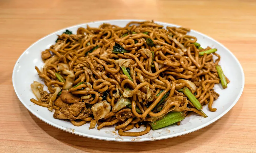 Plate of hearty thick stir-fried noodles mixed with egg, cabbage, greens and savory brown sauce at Eat Time, a Chinese Restaurant in Burien